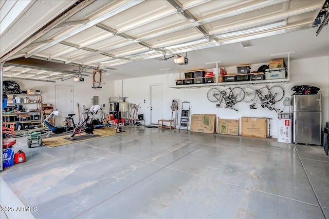 garage with stainless steel fridge and a garage door opener