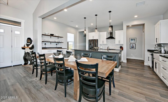 dining space featuring vaulted ceiling, dark wood-type flooring, and sink