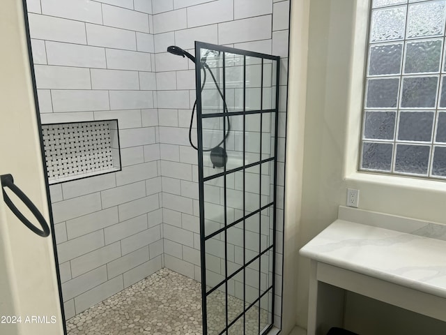 bathroom featuring a tile shower and vanity