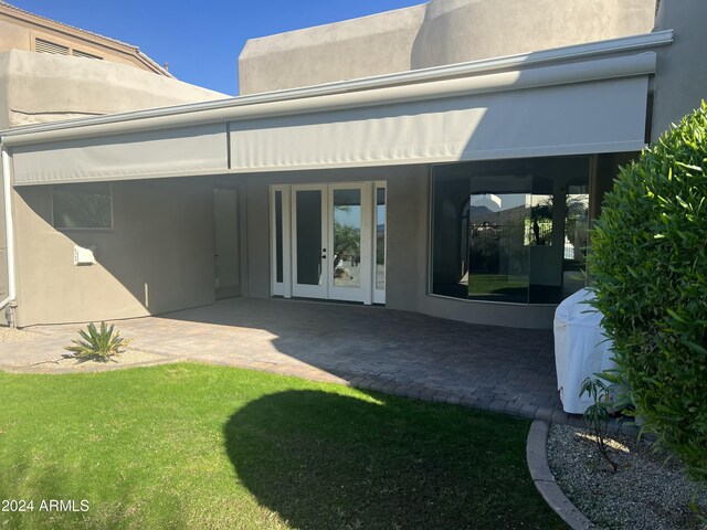 back of property with a patio area, a yard, and french doors