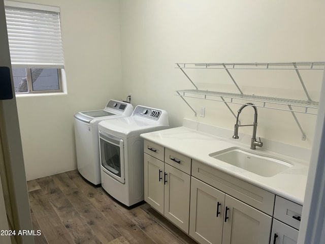 washroom featuring cabinets, dark hardwood / wood-style flooring, washing machine and dryer, and sink