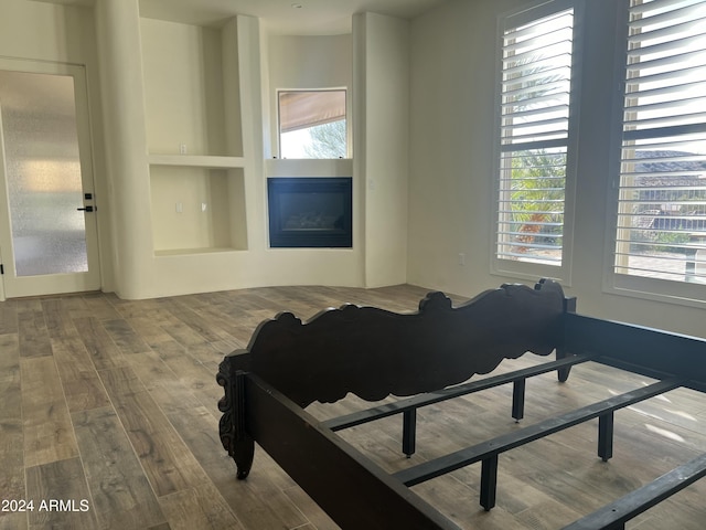 bedroom with multiple windows and hardwood / wood-style flooring