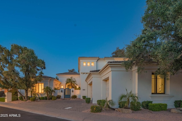 9905 N 78th Pl, Scottsdale, AZ 85258 - mediterranean / spanish home featuring stucco siding, a tiled roof, decorative driveway, and a gate