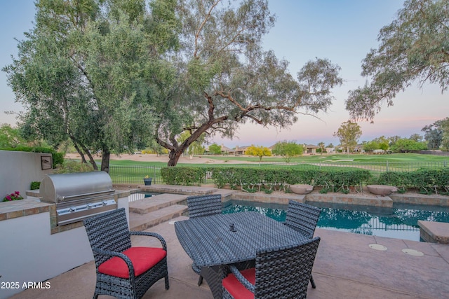 9905 N 78th Pl, Scottsdale, AZ 85258 - patio terrace at dusk with an outdoor pool, grilling area, a fenced backyard, and area for grilling