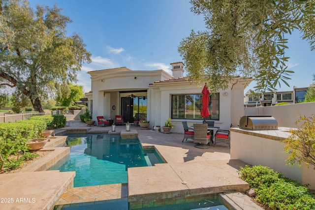 9905 N 78th Pl, Scottsdale, AZ 85258 - rear view of house with an outdoor kitchen, a patio area, fence, a chimney, and a fenced in pool