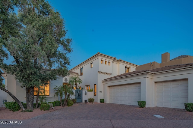 9905 N 78th Pl, Scottsdale, AZ 85258 - view of front of house with a garage, a tile roof, stucco siding, a gate, and decorative driveway