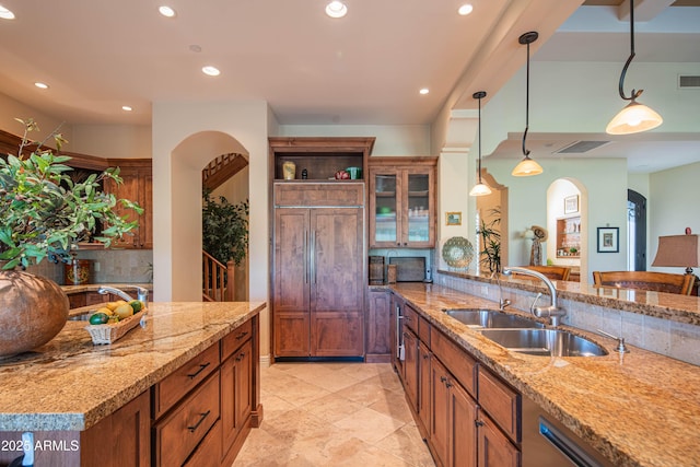 9905 N 78th Pl, Scottsdale, AZ 85258 - kitchen with paneled fridge, brown cabinetry, arched walkways, recessed lighting, and a sink