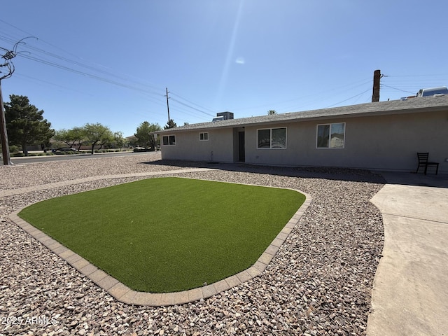 5042 S 22nd St, Phoenix, AZ 85040 - rear view of property with stucco siding and a yard