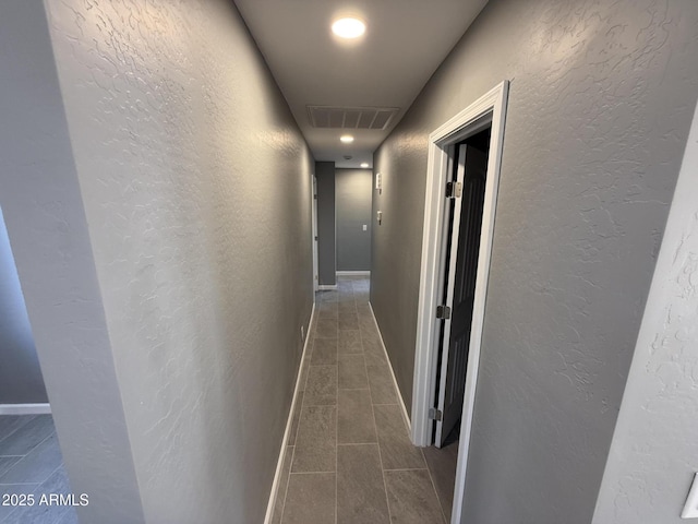 5042 S 22nd St, Phoenix, AZ 85040 - corridor with dark tile patterned flooring, a textured wall, and baseboards