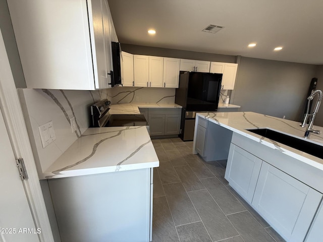 5042 S 22nd St, Phoenix, AZ 85040 - kitchen featuring freestanding refrigerator, light stone countertops, recessed lighting, electric range, and white cabinets