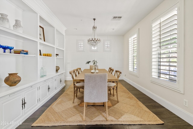 dining area with built in shelves, a notable chandelier, and dark hardwood / wood-style floors