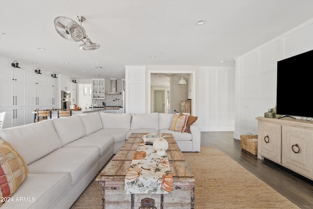 living room featuring sink and dark wood-type flooring