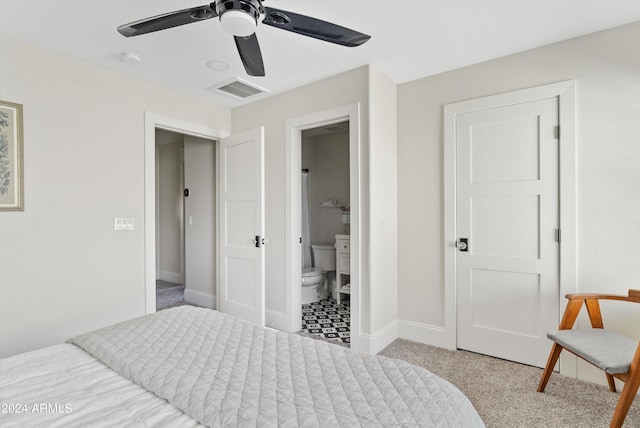 bedroom featuring ensuite bath, light colored carpet, and ceiling fan