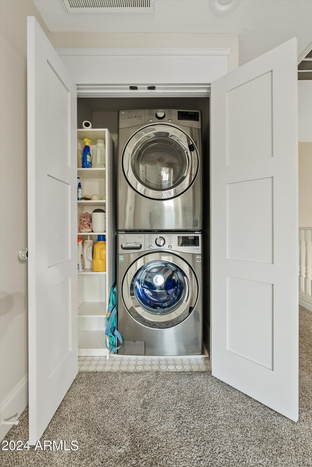 laundry room with carpet floors and stacked washer and clothes dryer