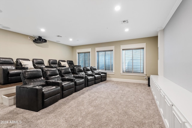 carpeted home theater featuring ornamental molding