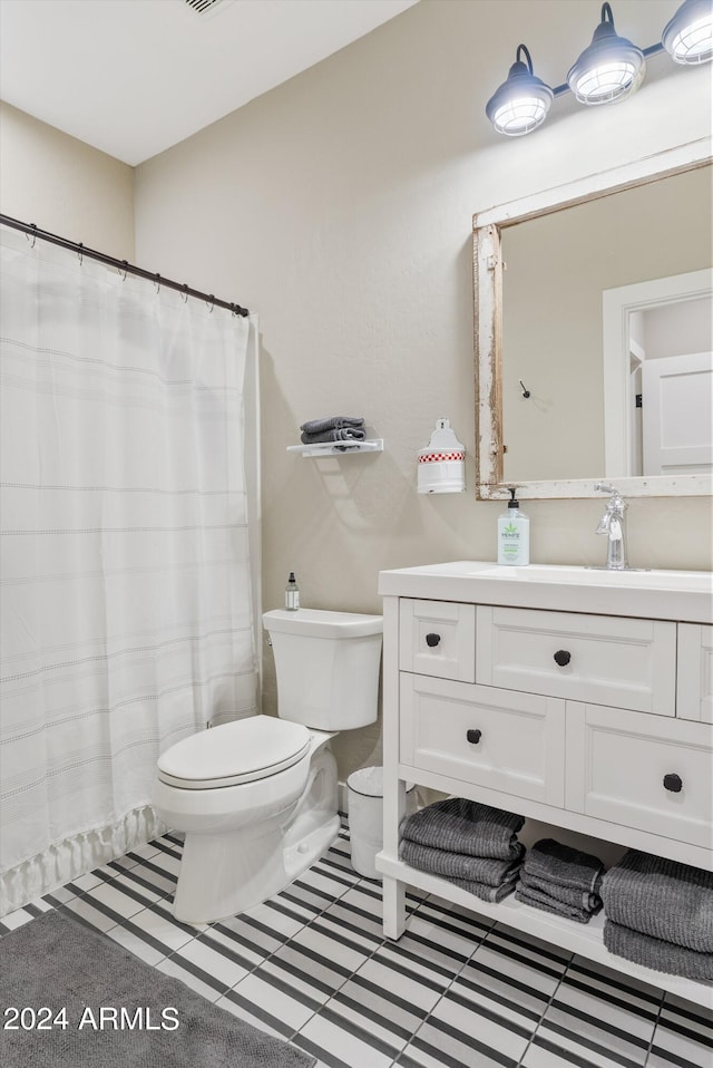 bathroom featuring vanity, curtained shower, and toilet