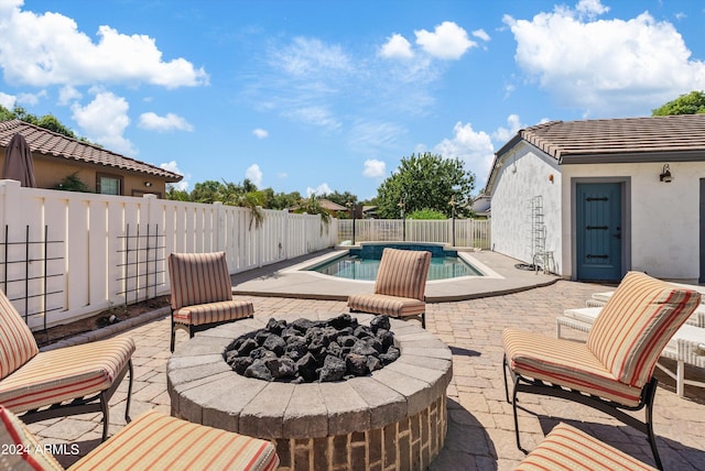 view of pool featuring an outdoor fire pit and a patio