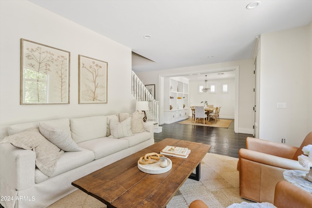 living room with light hardwood / wood-style floors and a notable chandelier