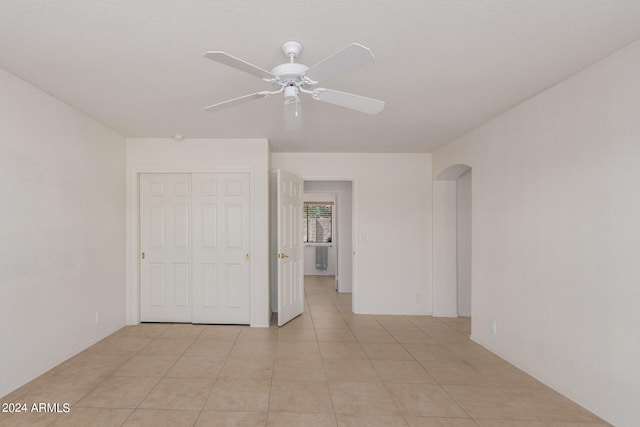 tiled empty room featuring ceiling fan