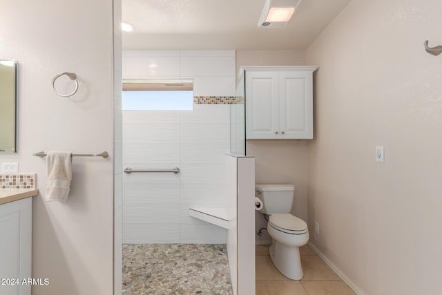 bathroom with vanity, toilet, tiled shower, a textured ceiling, and tile patterned flooring