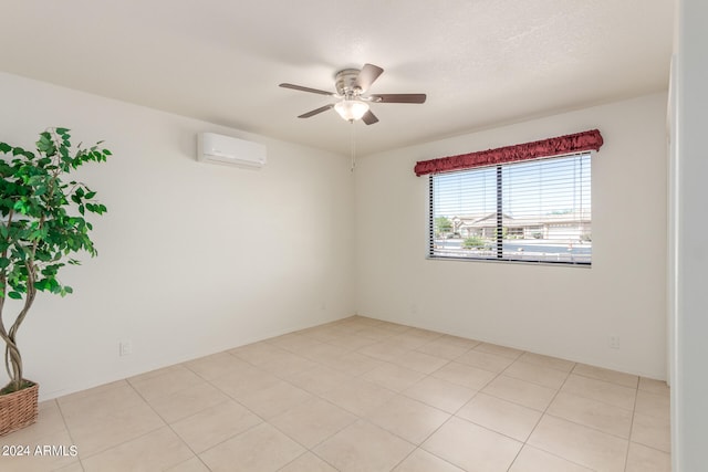 empty room with ceiling fan, light tile patterned flooring, and a wall mounted air conditioner