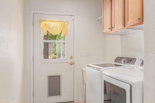 laundry area featuring washing machine and dryer and cabinets