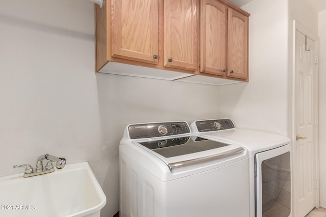 washroom with cabinets, separate washer and dryer, and sink