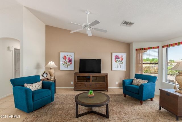 living room featuring ceiling fan, light tile patterned floors, and vaulted ceiling