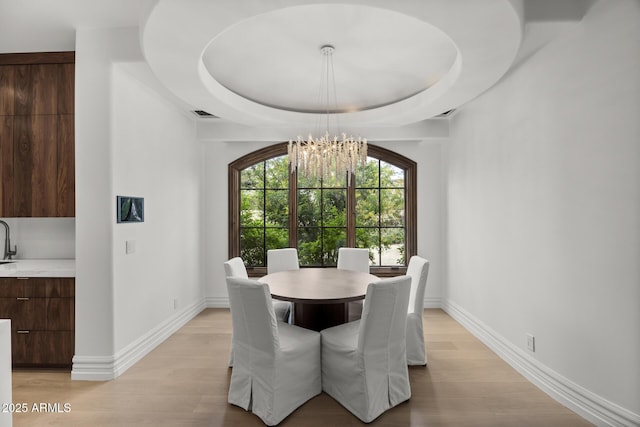 6852 E Fanfol Dr, Paradise Valley, AZ 85253 - dining room with an inviting chandelier, a tray ceiling, light wood finished floors, baseboards, and visible vents