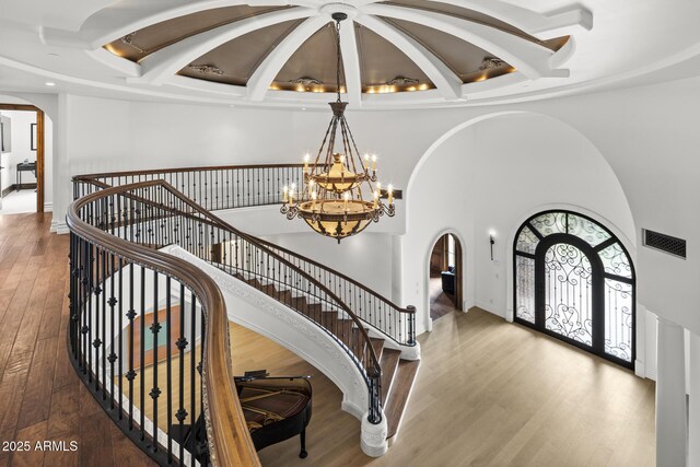6852 E Fanfol Dr, Paradise Valley, AZ 85253 - foyer with visible vents, arched walkways, an inviting chandelier, wood finished floors, and coffered ceiling