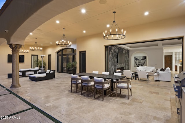 6852 E Fanfol Dr, Paradise Valley, AZ 85253 - dining area featuring arched walkways, an inviting chandelier, stone tile flooring, decorative columns, and recessed lighting