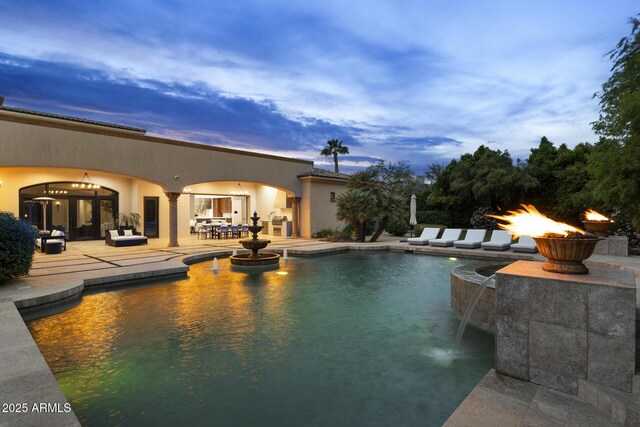 6852 E Fanfol Dr, Paradise Valley, AZ 85253 - pool at dusk with a patio area and an outdoor fire pit