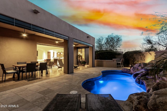 pool with a patio, outdoor dining area, and a ceiling fan