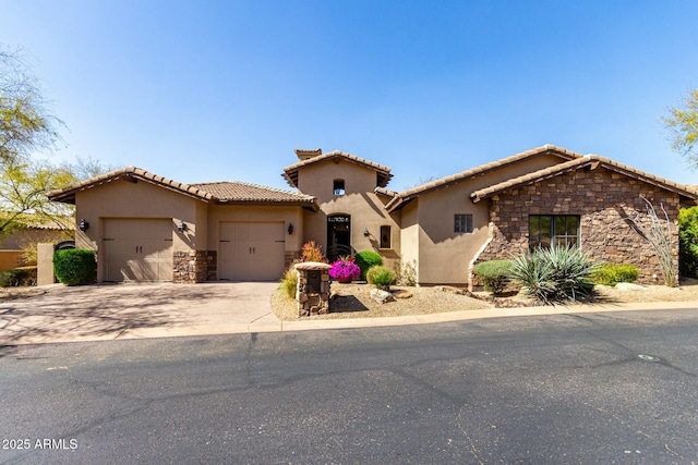 mediterranean / spanish-style home with driveway, stone siding, a tiled roof, an attached garage, and stucco siding