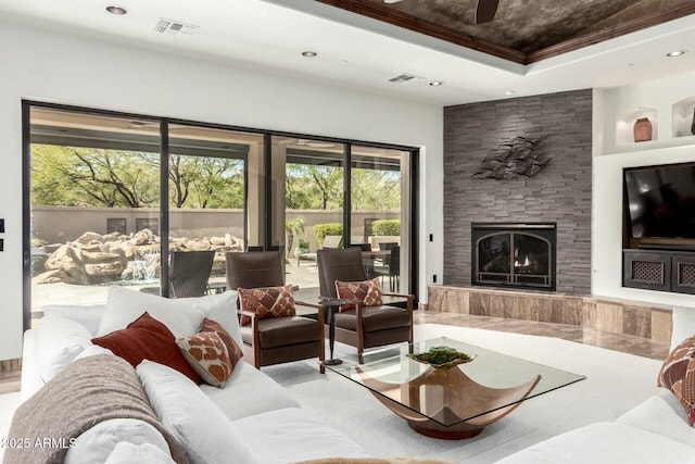 living room featuring recessed lighting, a raised ceiling, visible vents, and a tiled fireplace