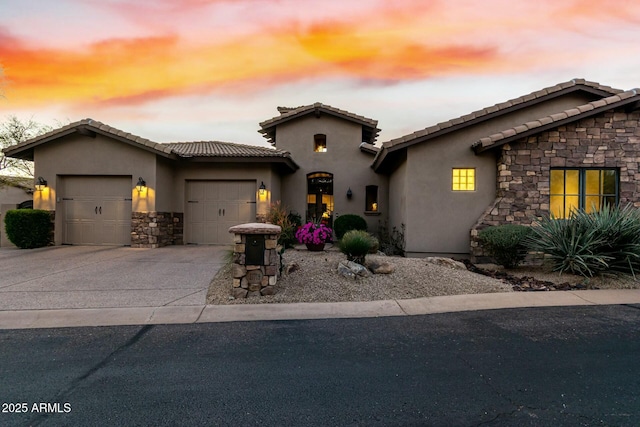 view of front facade featuring stucco siding, a garage, stone siding, driveway, and a tiled roof