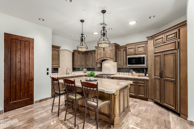 kitchen featuring visible vents, decorative backsplash, stainless steel microwave, a breakfast bar, and a center island