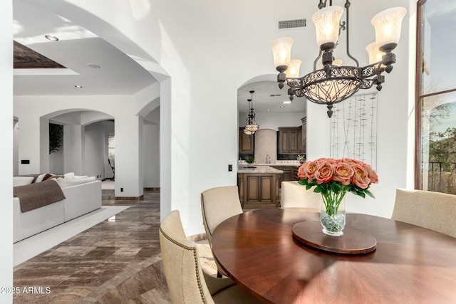 dining area featuring arched walkways, visible vents, recessed lighting, and an inviting chandelier