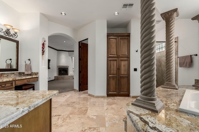 bathroom featuring recessed lighting, a fireplace, vanity, baseboards, and visible vents