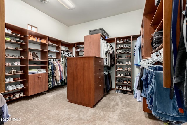 walk in closet with visible vents and light colored carpet