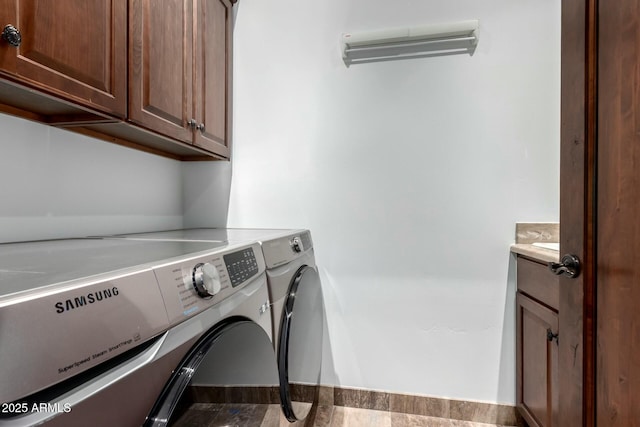 laundry room with separate washer and dryer and cabinet space