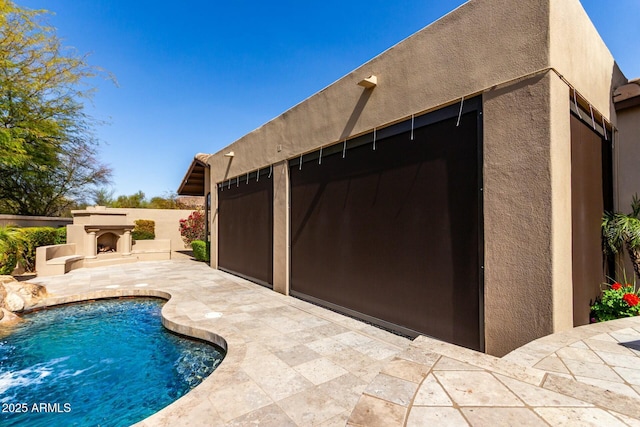 view of pool featuring a patio and an outdoor fireplace