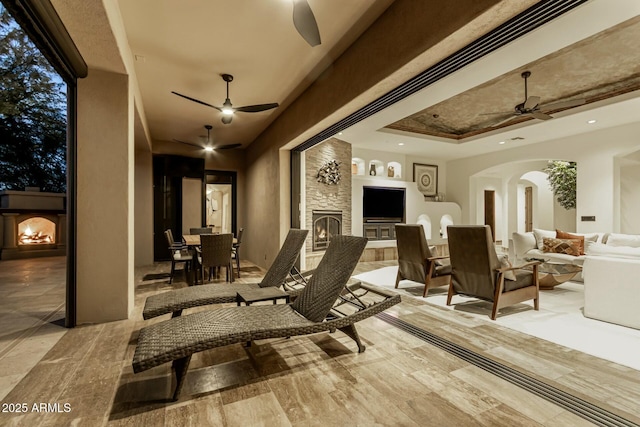 view of patio featuring an outdoor living space with a fireplace, a ceiling fan, and outdoor dining space