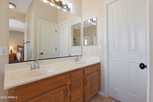 bathroom featuring tile patterned flooring, vanity, and a shower with shower door