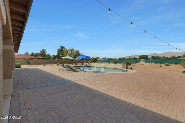 view of swimming pool featuring a mountain view and a patio