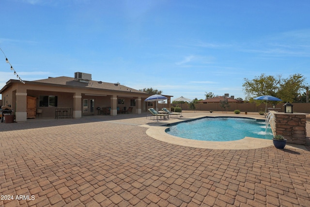 view of swimming pool featuring pool water feature and a patio