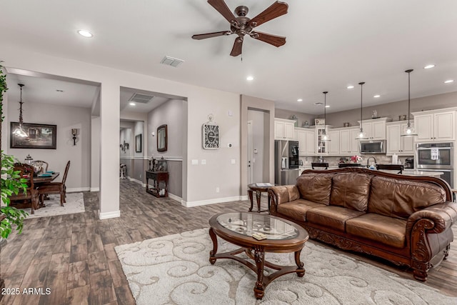 living room featuring wood finished floors, visible vents, and recessed lighting