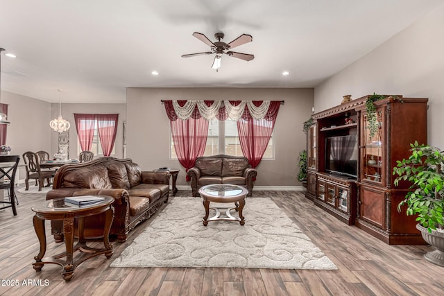 living room featuring a ceiling fan, plenty of natural light, light wood-style flooring, and baseboards