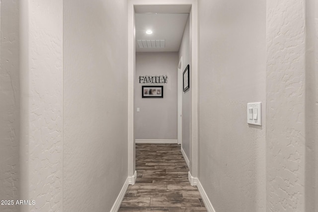 hall with baseboards, visible vents, dark wood finished floors, and a textured wall