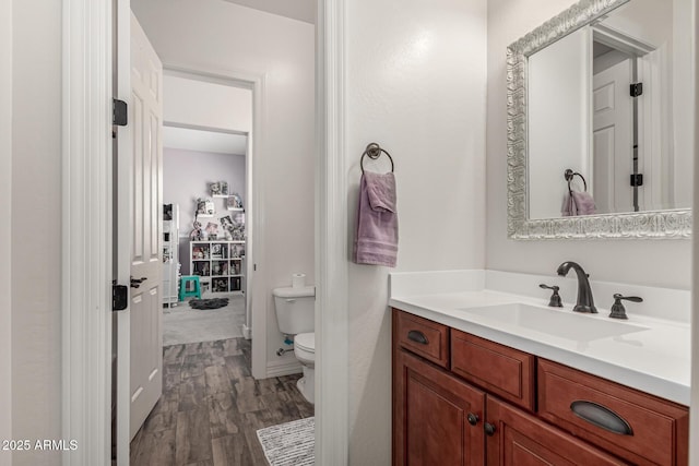 bathroom with vanity, toilet, and wood finished floors